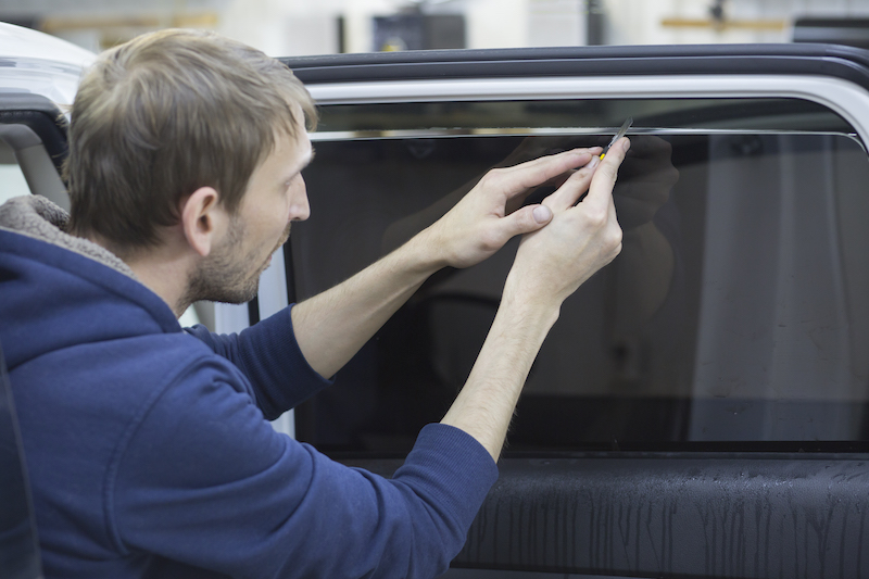 man installing window film