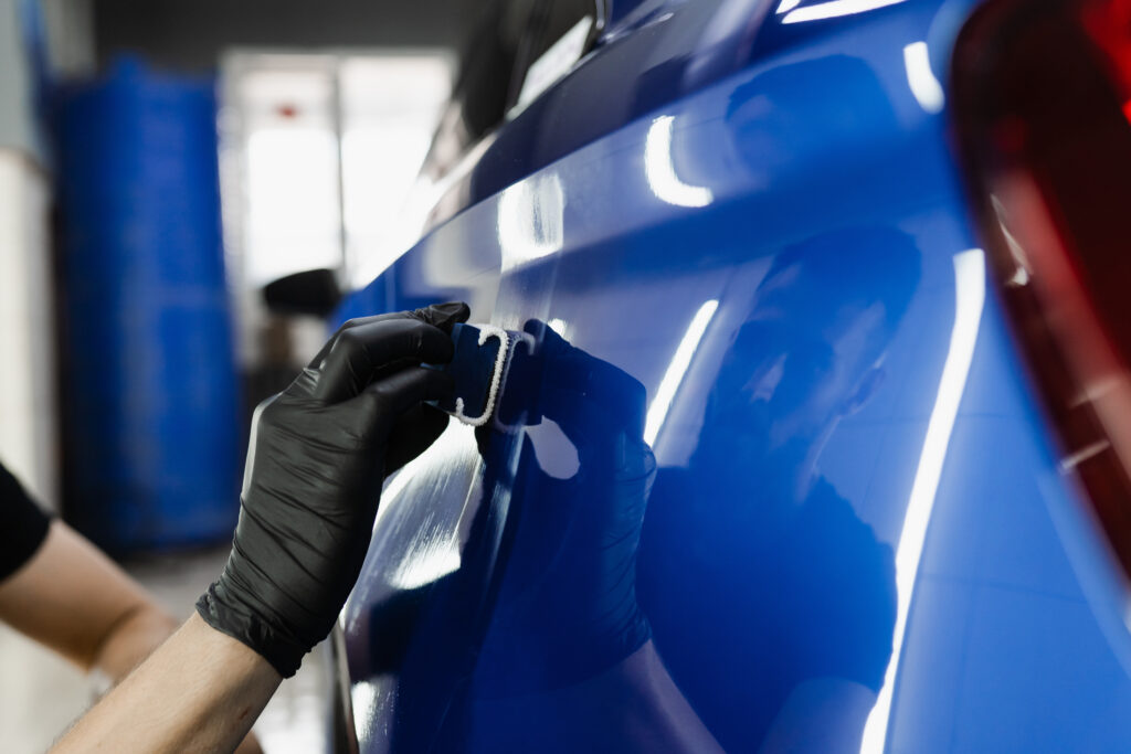 ceramic coating being applied to a blue car
