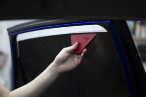Person tinting car windows with ceramic 3M films. Window film for car.