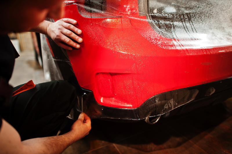 Bright red car with PPF being installed 