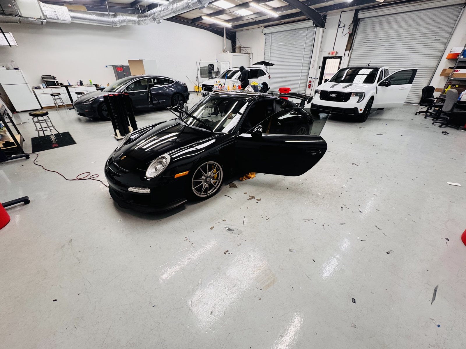 Black Porsche 911 inside The Tint Guy shop
