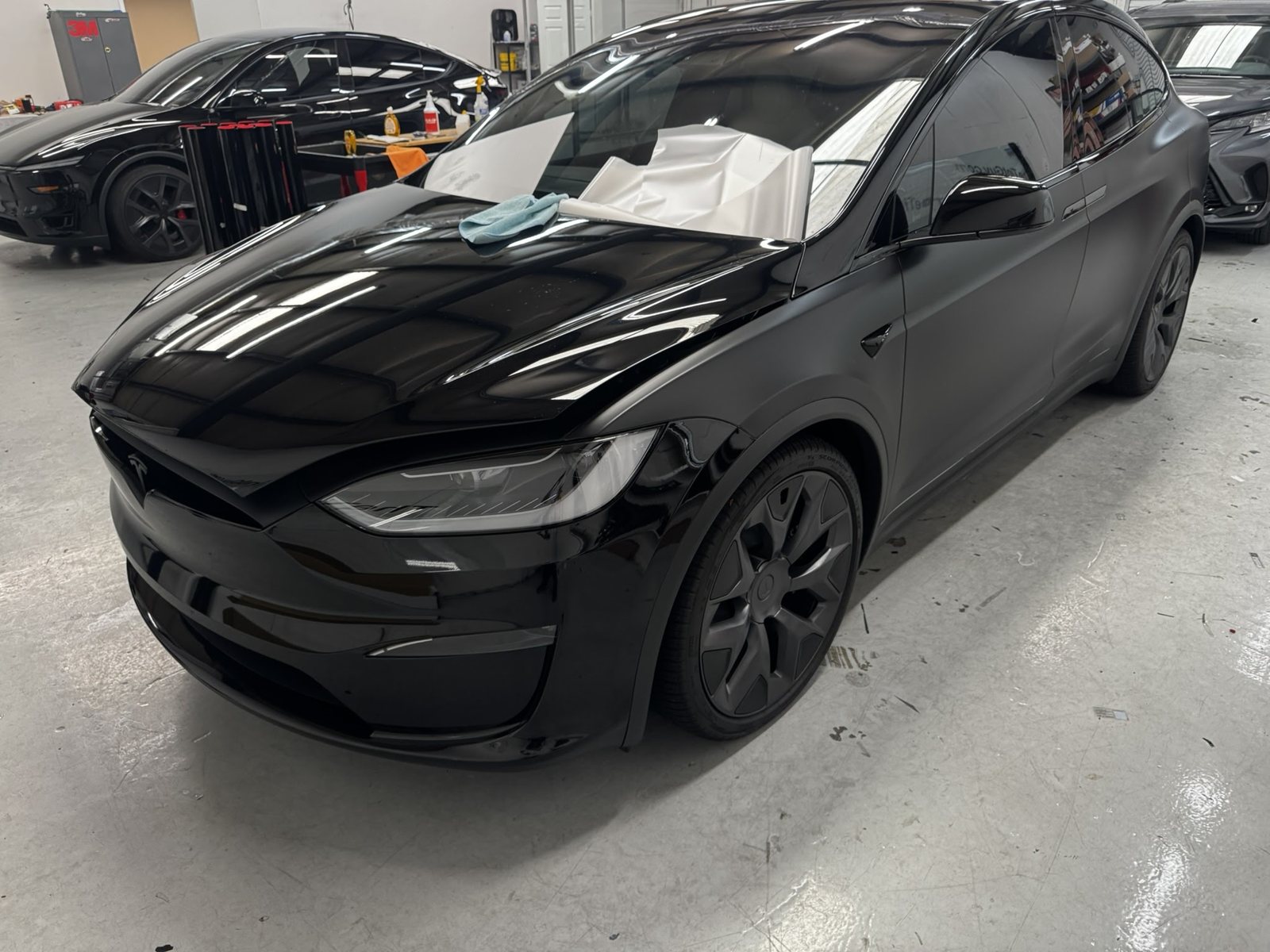 Black Tesla Model X inside The Tint Guy shop