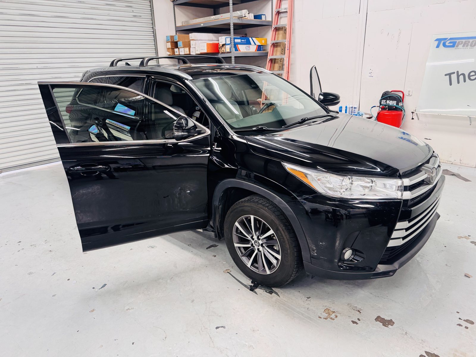 Black Toyota Highlander with the door open for window tint inside The Tint Guy