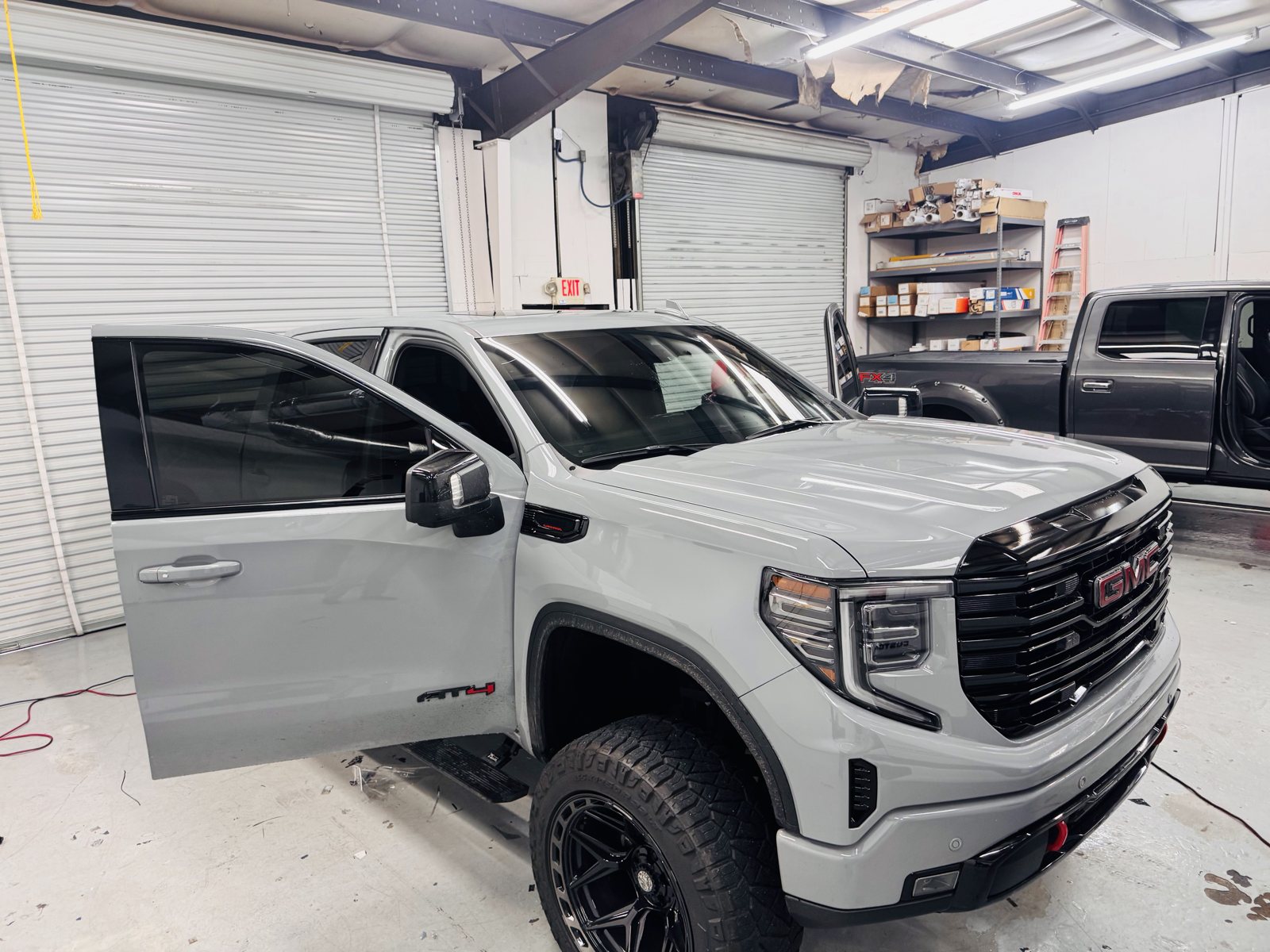 Gray GMC Sierra with the doors open for window tint inside The Tint Guy