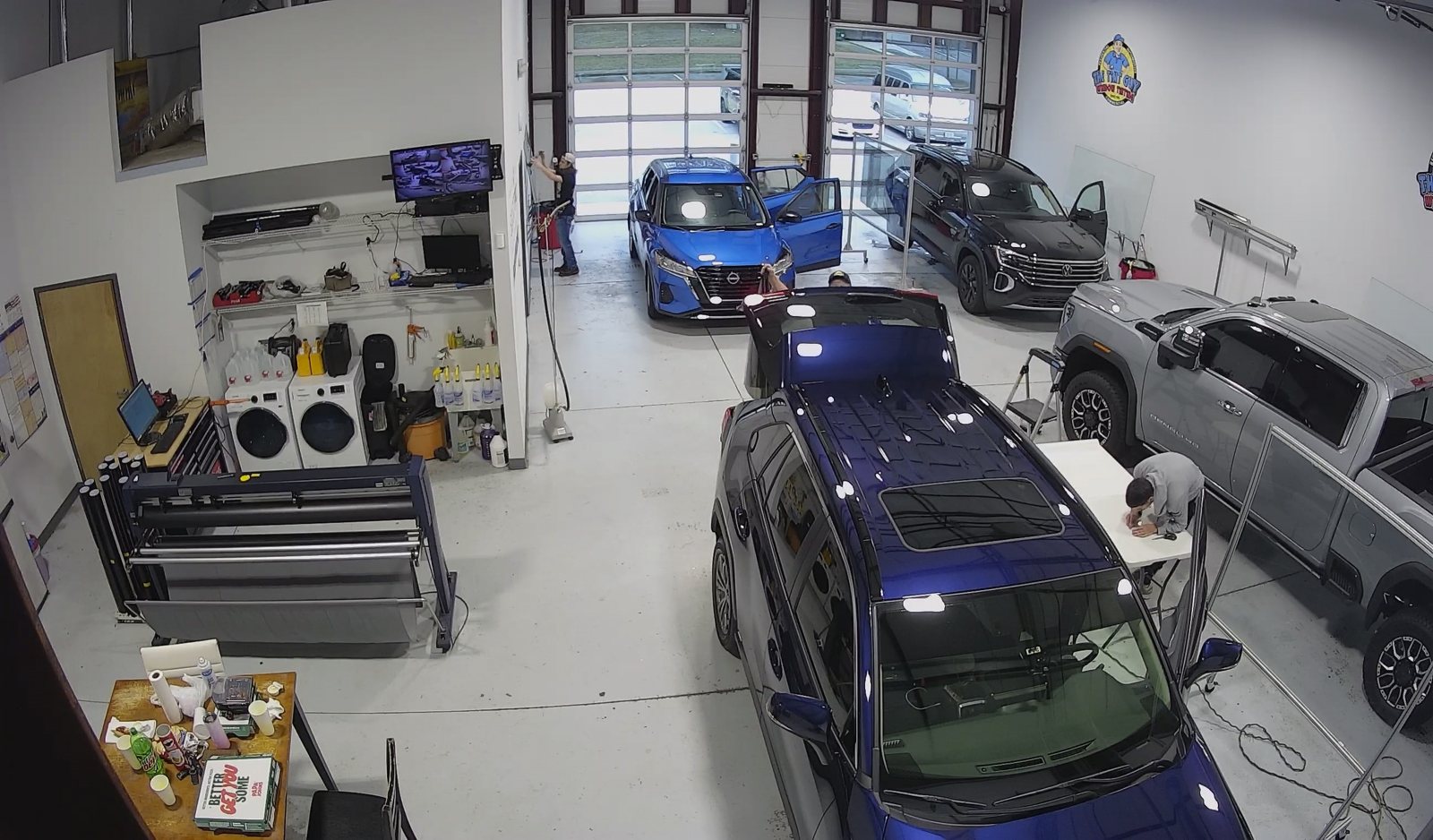 Inside The Tint Guy shop with vehicles in the install bays