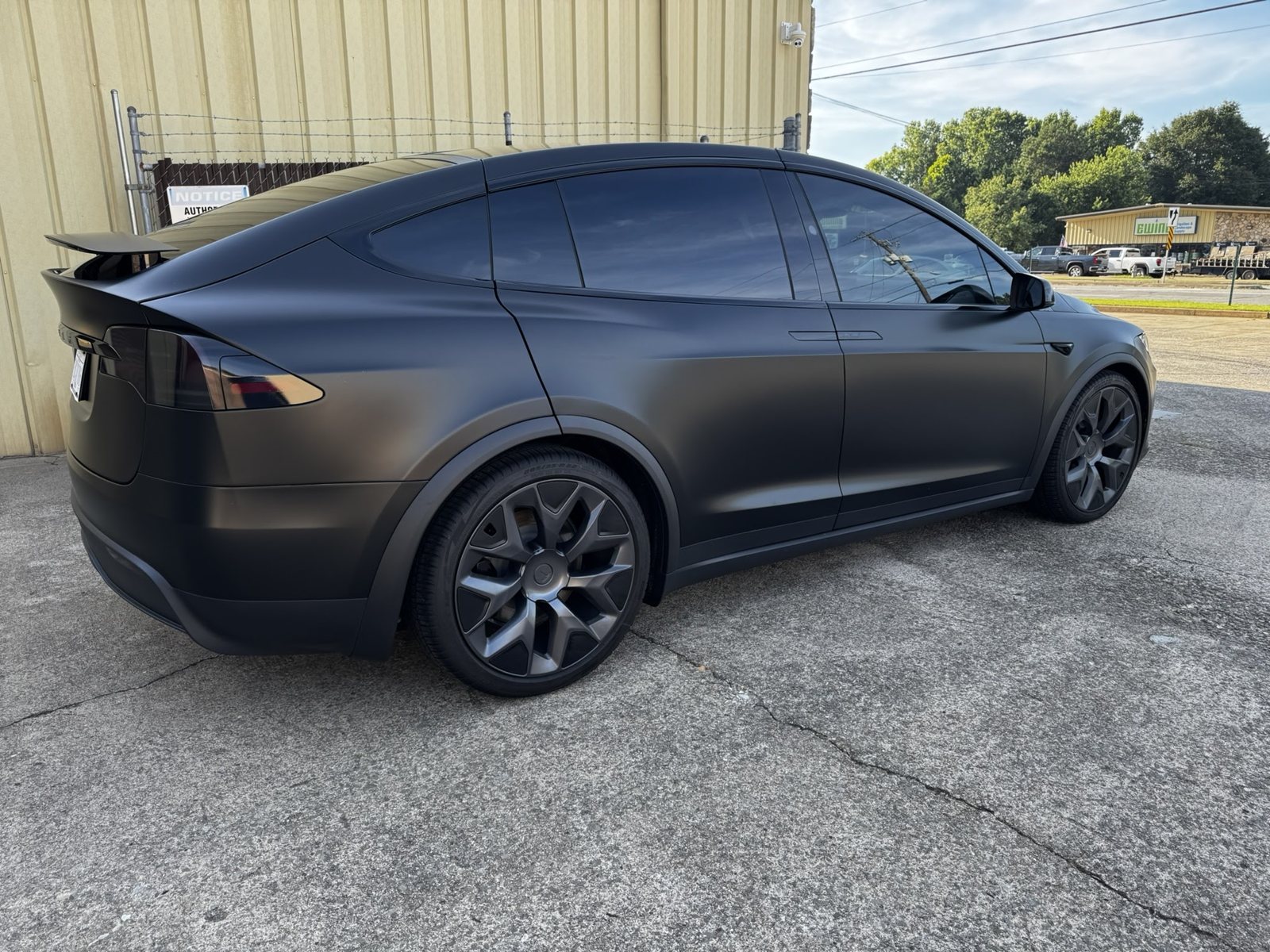 Matte black Tesla Model X outside The Tint Guy shop