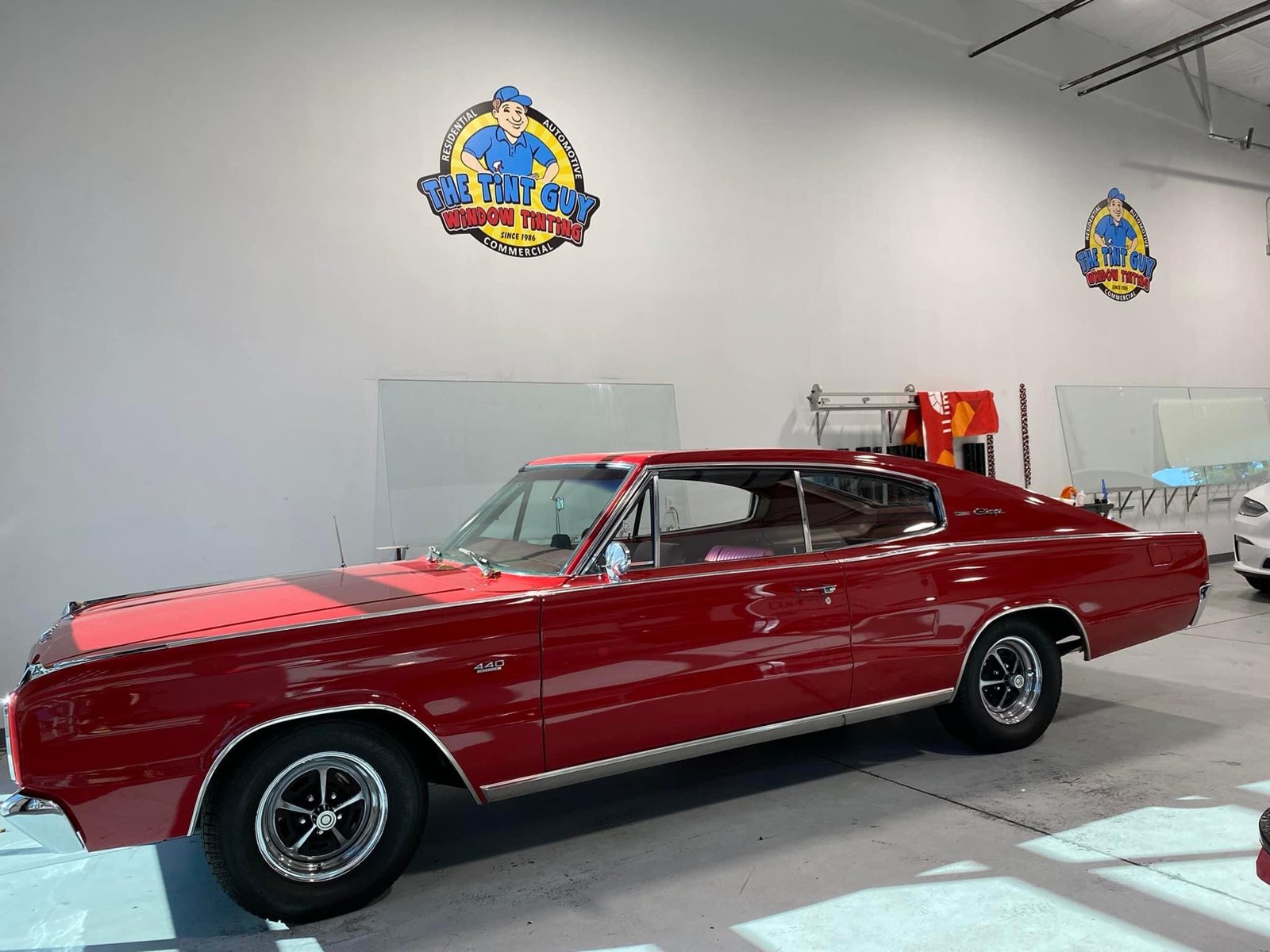Red classic Dodge Charger inside The Tint Guy shop