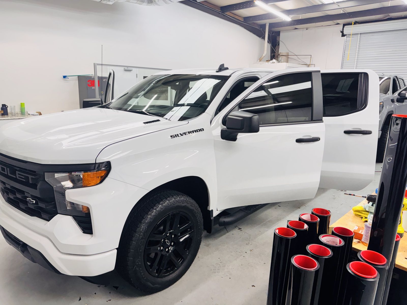 White Chevy Silverado with the doors open for window tint inside The Tint Guy