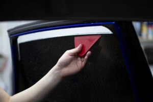 Person tinting car windows with ceramic 3M films. Window film for car.