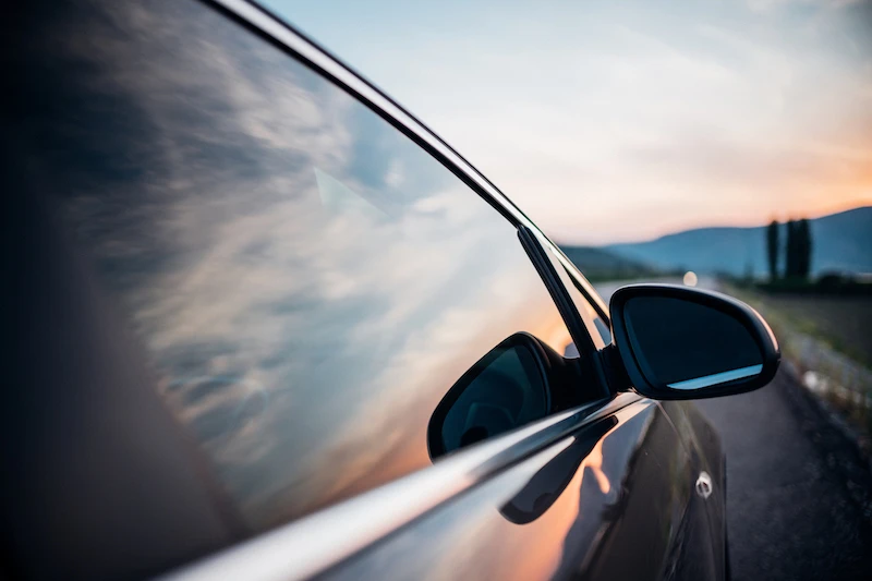 Mirror view of car with sunset